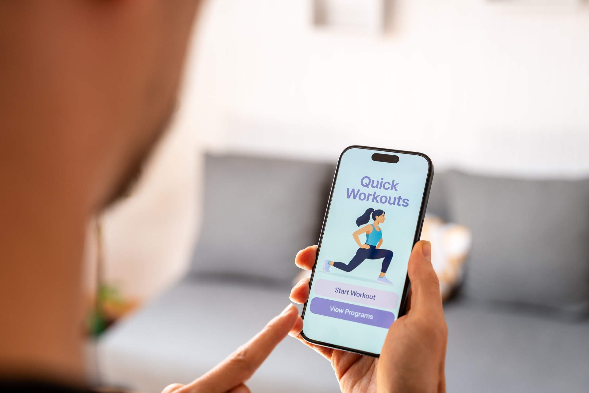 Man using fitness app on smartphone at home for quick workouts